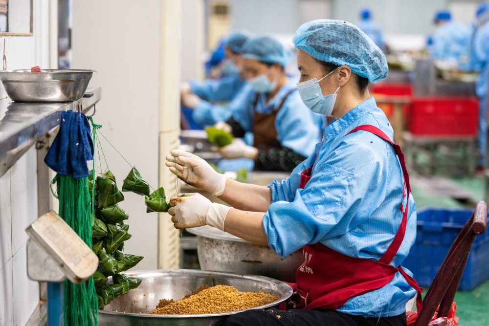 6月5日，在浏阳市关口街道道源湖村一家粽子生产车间，工人在包粽子。