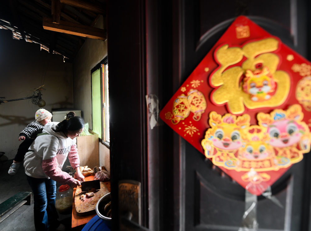 2月2日，巴木玉布木在切鸡肉准备晚餐。新华社记者 王曦 摄