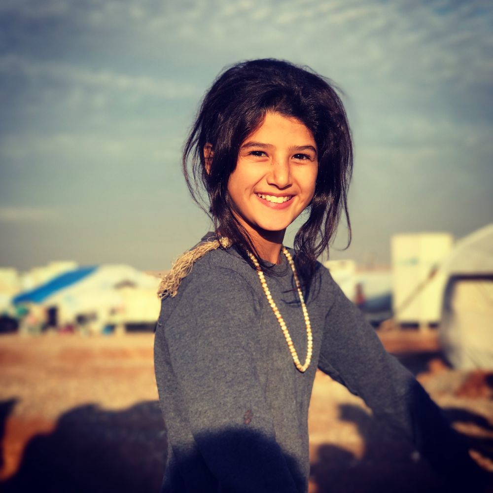 2016年12月22日，伊拉克北部的一座难民营里，从摩苏尔逃离的女孩脸上绽放着灿烂的笑容。