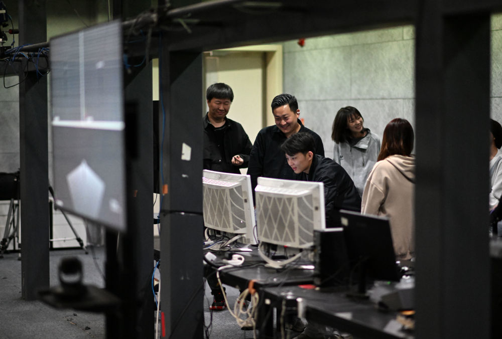 崔盛辑（左二）和同事在动作捕捉棚内查看动作捕捉数据（4月23日摄）。
