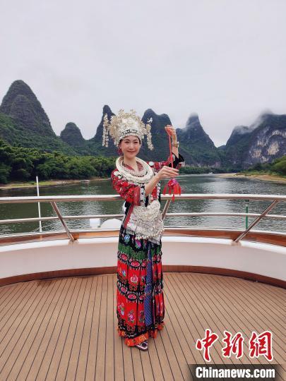 2023年10月，泰国女孩马惠桢穿着苗族服饰乘游船游览漓江。(受访者供图)
