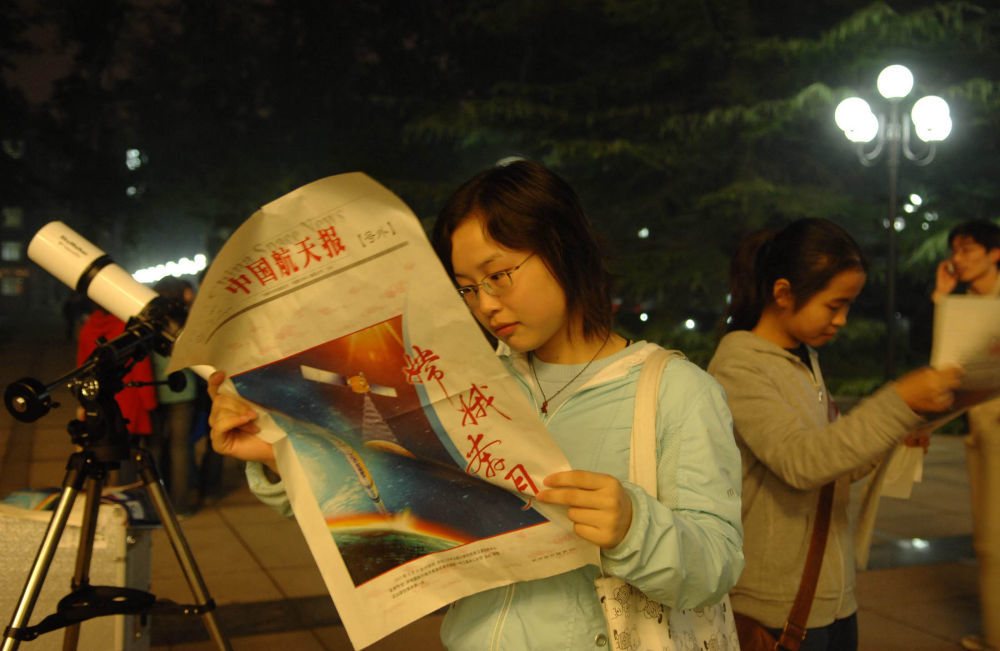 2007年10月24日，北京航空航天大学一名学生在翻看《中国航天报》号外。新华社记者 罗晓光 摄