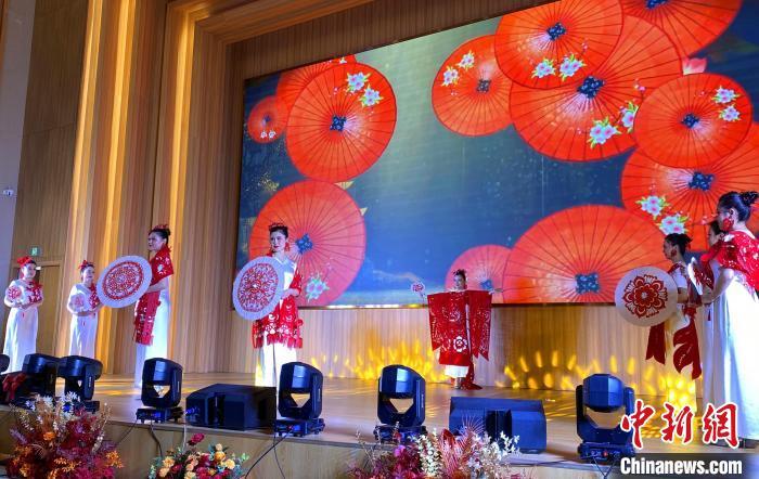 9名身着龙凤呈祥、年年有余(鱼)、富贵牡丹等主题红色剪纸服饰的女子，在悠扬的乐曲中款款走秀，让国家级“非遗”——中国剪纸流动起来。韩欢欢 摄
