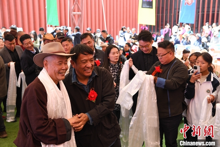 图为市民为西藏牦牛博物馆创始人、荣誉馆长吴雨初献上哈达祝福。 中新社记者 贡嘎来松 摄