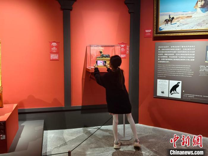 4月13日，一名中国小朋友用手机拍摄保护罩内的文物。　苏婧欣 摄