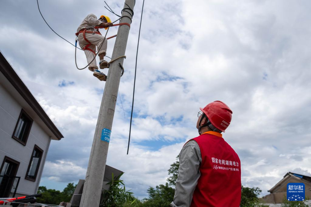 7月29日，在湖南省湘潭县易俗河镇四新堤决口现场，抢险人员在处理决口附近的电线。新华社记者 陈思汗 摄