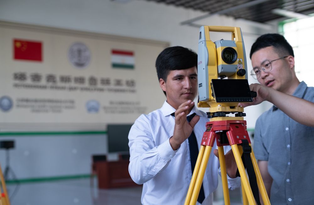 ↑6月14日，来自天津城市建设管理职业技术学院的老师（右）在塔吉克斯坦首都杜尚别的鲁班工坊内指导学生。