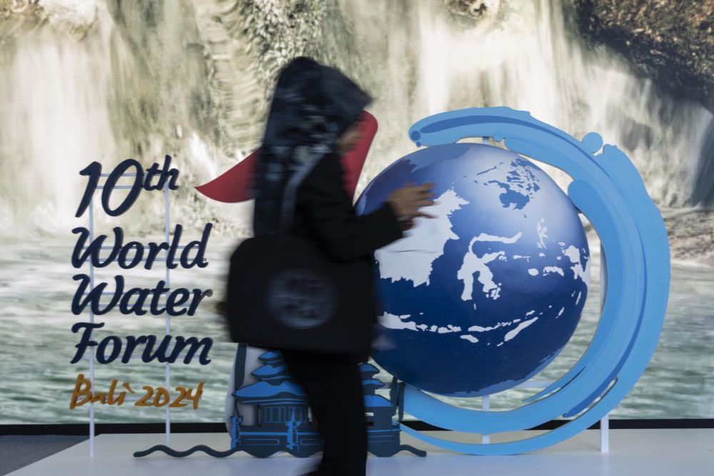 5月20日，在印度尼西亚巴厘岛，一名行人经过第十届世界水论坛标识。第十届世界水论坛20日在印度尼西亚巴厘岛开幕，这是世界水论坛首次在东南亚国家举办。本届论坛以“水促进共享繁荣”为主题，将围绕水安全与繁荣、人类与自然用水、减灾与管理、治理合作与水外交、可持续水融资、知识与创新等议题举办多场会议。新华社发（维里摄）