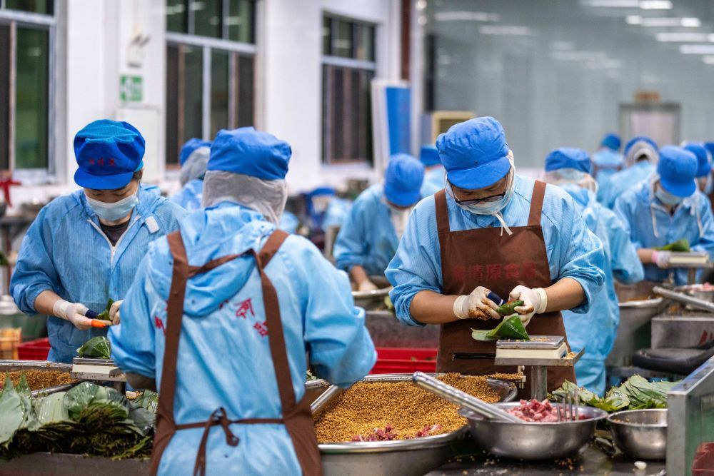 6月5日，在浏阳市关口街道道源湖村一家粽子生产车间，工人在包粽子。