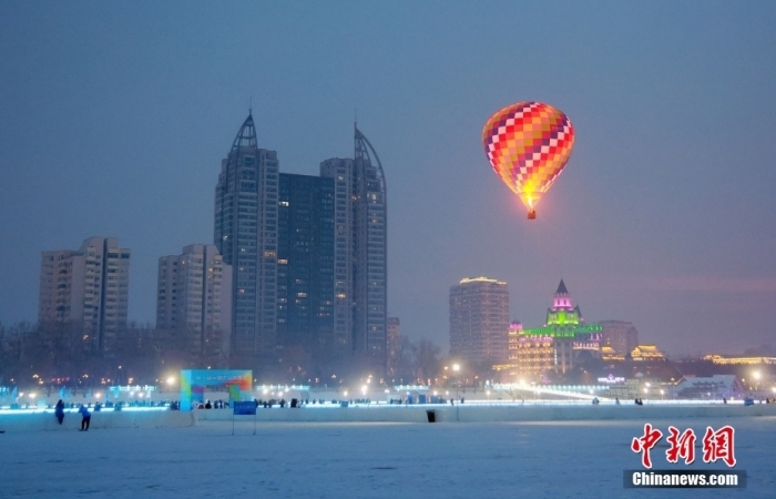 图为松花江冰雪嘉年华园区，一个颜色鲜艳的热气球成为受游客追捧的热点体验项目。图/视觉中国