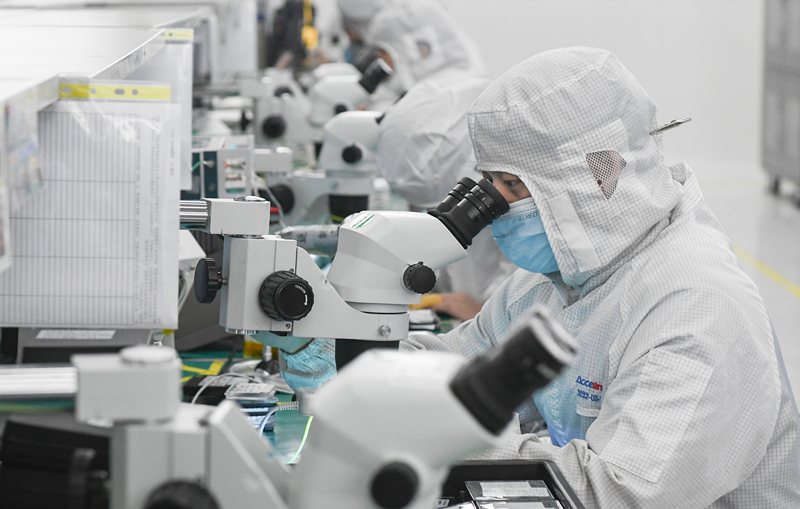 2023年4月11日，武汉光迅科技股份有限公司生产车间内，技术人员在光模块生产线作业。