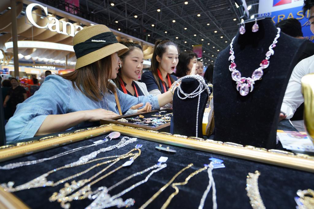 4月15日，参观者在消博会上选购珠宝首饰。新华社记者 李梦娇 摄