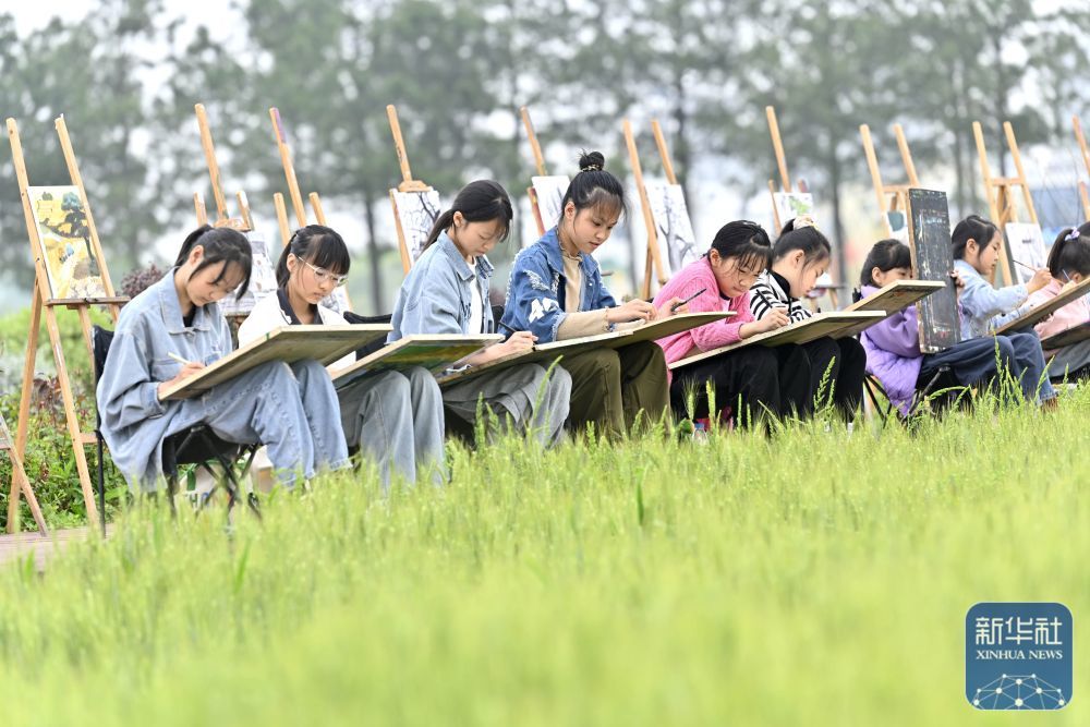 4月27日，在浙江省嘉兴市南湖区余新镇，孩子们在麦田边作画。新华社发（黎寒池摄）