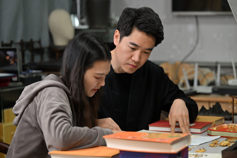 马赛（右）和女朋友闵方苹（左）在工作室内讨论设计稿（3月19日摄）。新华社记者 李然 摄