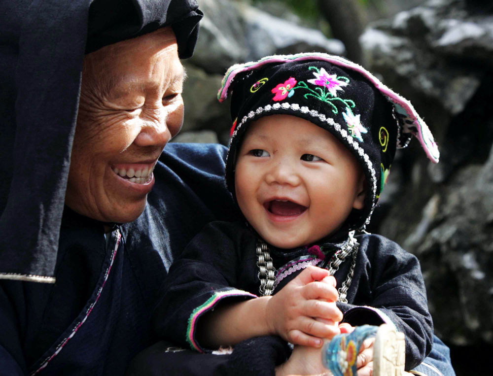 2009年8月28日，广西百色那坡县黑衣壮山寨吞力屯村民脸上露出笑容。