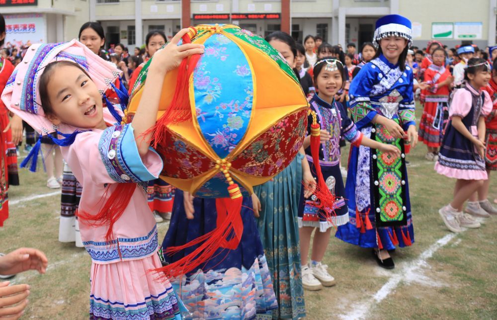2024年4月9日，在广西武宣县实验小学城南校区，师生们在传递绣球。新华社发（陈冬梅 摄）