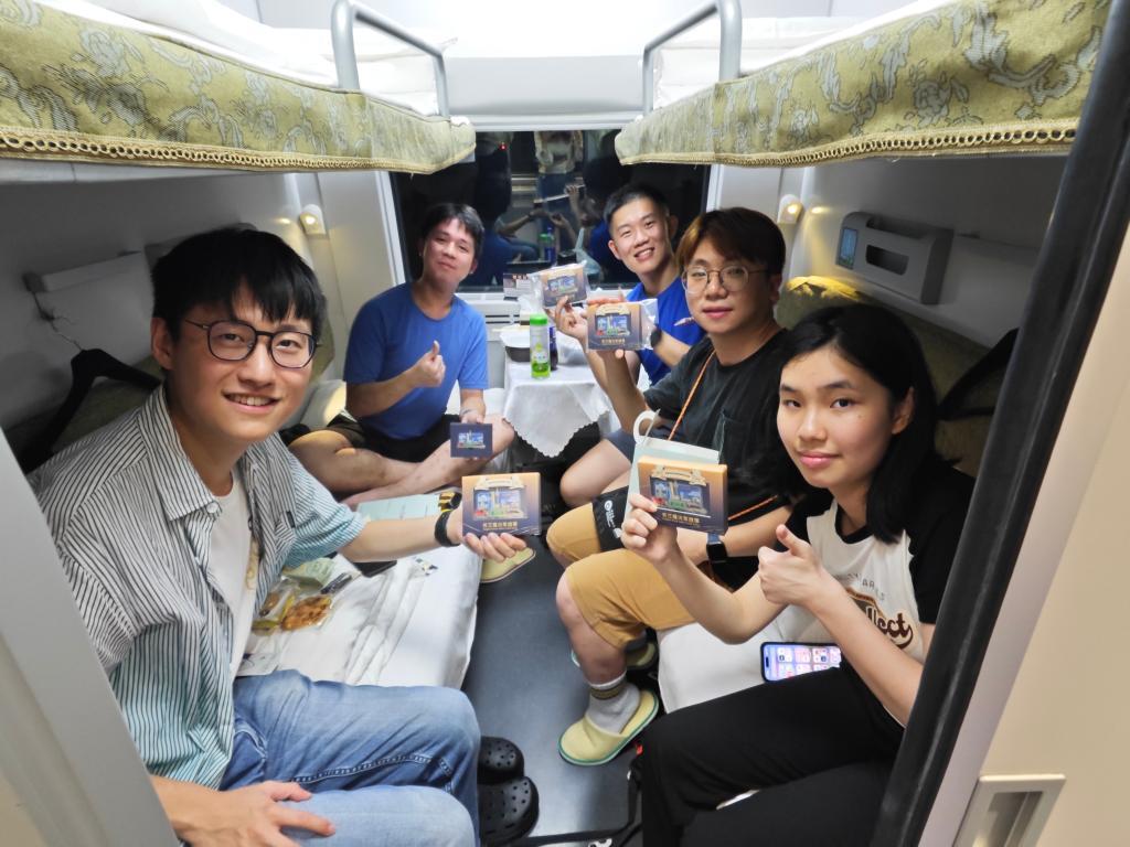 6月15日，乘客在香港西九龙至上海虹桥D908次高铁动卧列车上展示收到的首班车纪念品。新华社记者 褚萌萌 摄