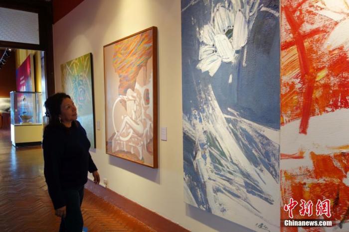 资料图：当地时间2016年11月18日，利马，一名秘鲁女观众观看APEC“人与自然”艺术展。11月16日，为期23天的“感知中国走进秘鲁——APEC‘人与自然’艺术展”在秘鲁国家考古人类学历史博物馆举办。 中新社记者 莫成雄 摄