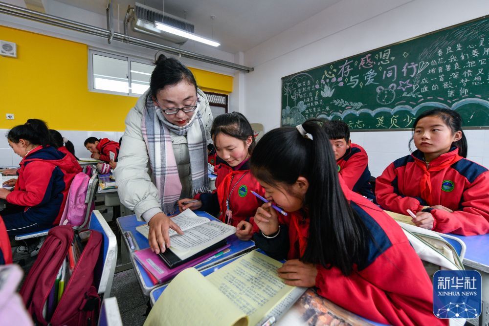 2月26日，积石山县石塬镇肖红坪小学的老师给学生辅导作业。