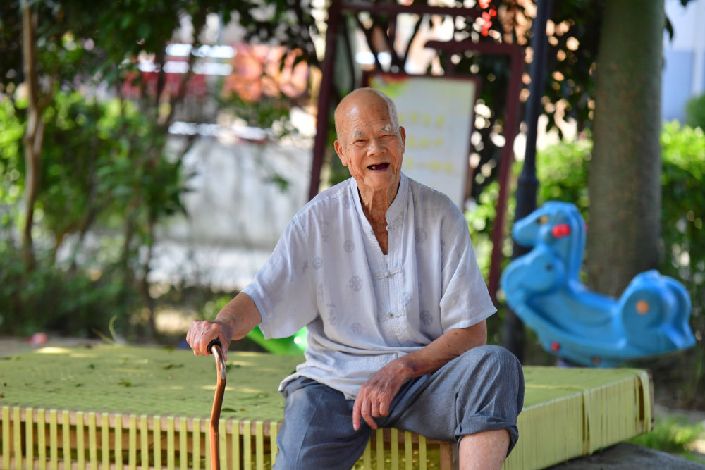 93岁的韦绍堂老人在小广场上休闲（5月23日摄）。