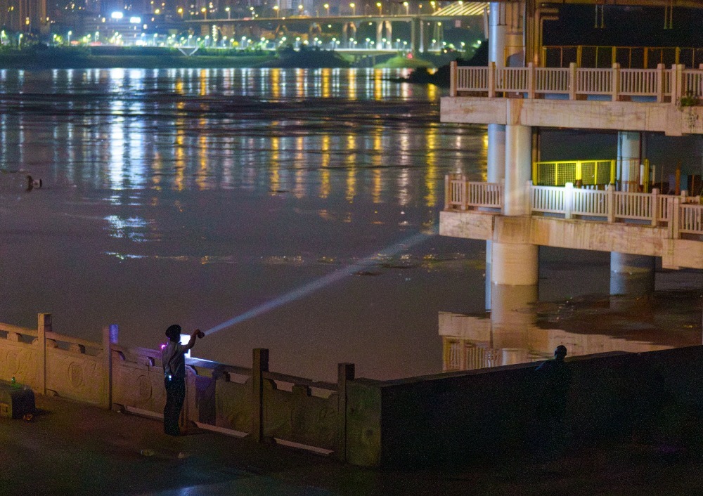 ▲7月12日凌晨，沙坪坝区磁器口码头，防汛值班员正在巡逻，确保没有市民在危险区域逗留。记者 李雨恒 摄