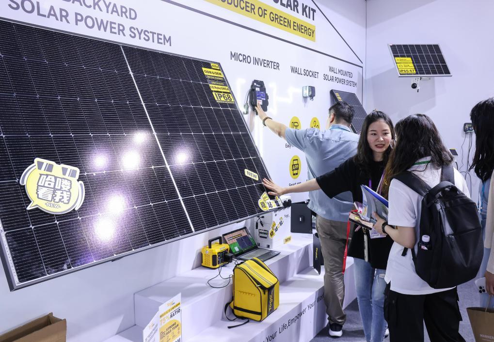 4月15日，参展商在第135届广交会上向采购商介绍太阳能电池组件展品。新华社记者刘大伟摄