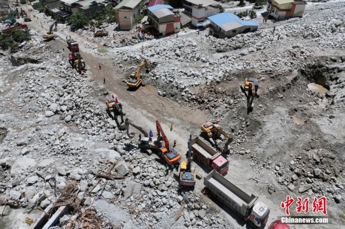 8月5日，四川省康定市姑咱终日地村“8·03”山洪泥石流318国谈受灾段济急通谈已抢通，拯救力量正在进行路面拓宽、降坡、填平、压实等谈路提高职责，时不我待接续交功课，力图受灾段早日通车。图为318国谈受灾段大型机械设备正加紧抢险功课。（无东谈主机相片）中新社记者 刘忠俊 摄