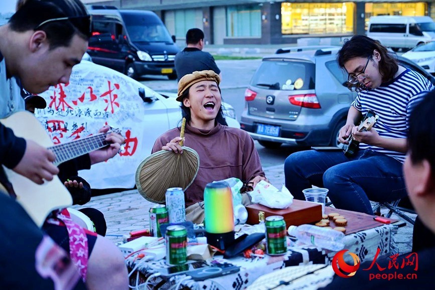 叶镇豪(左二)与满洲里当地的年轻人在街头高歌。人民网记者 寇雅楠摄