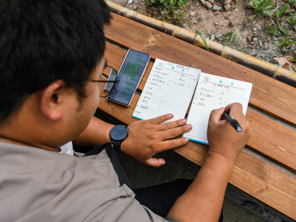 在四川省成都东部新区董家埂镇小河村，舒星宇在安排第二天的机插秧计划（5月15日摄）。