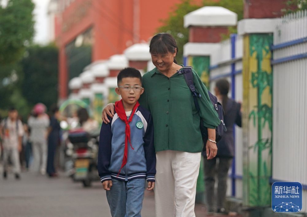 江西省铅山县县城，罗细英（右）接外孙放学（9月27日摄）。