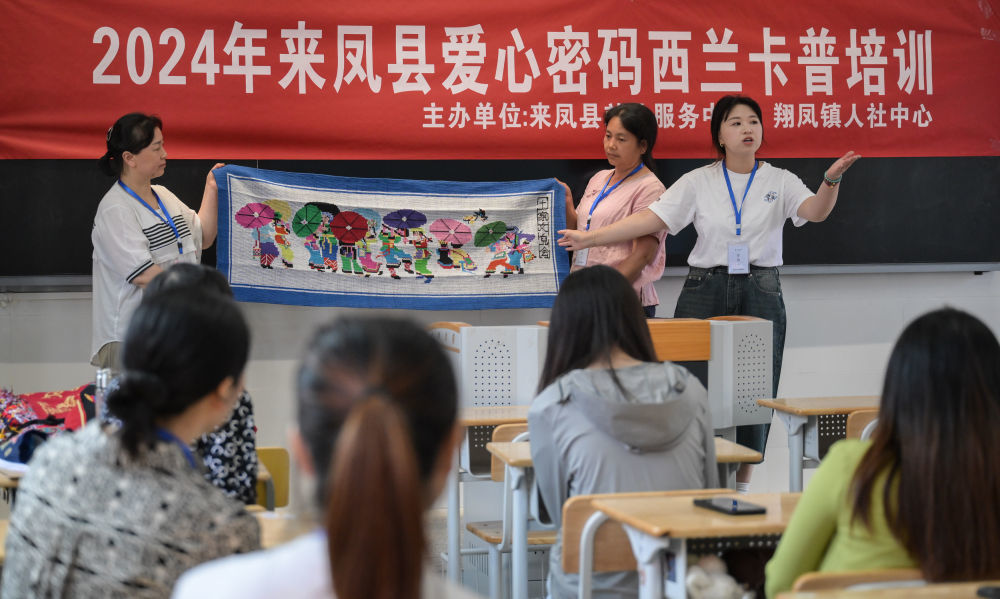 7月2日，唐洪祥的孙女唐鸣珂（后右一）在来凤县西兰卡普培训班上展示西兰卡普成品。今年29岁的唐鸣珂国外留学后回到家乡，从事西兰卡普的传承发展工作。