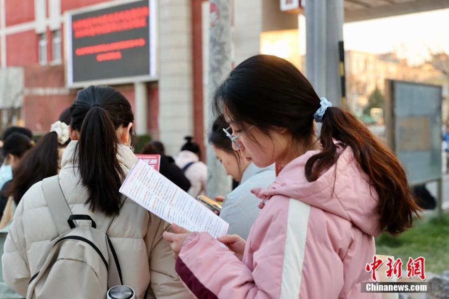 12月1日,北京首都师范大学附属丽泽中学初中部国考考点外,考生抓紧时间复习。中新社记者 易海菲 摄