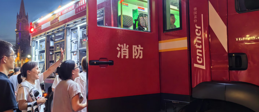 江畔纳凉散步的人们来到路边的消防车边学习消防知识 孟海鹰/摄