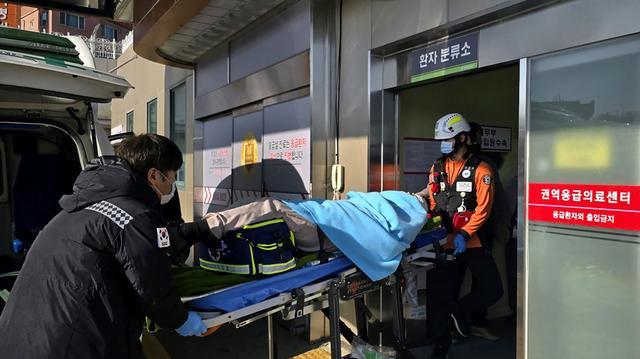 （韩国救援人员29日在失事现场救出一名伤者。）