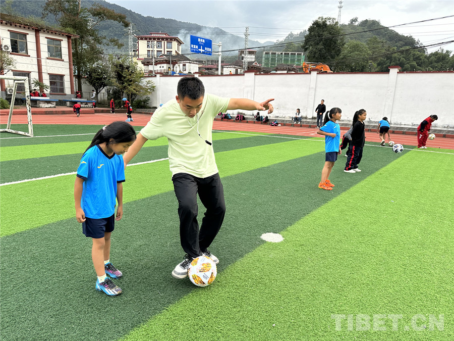 图为安超林进行足球教学