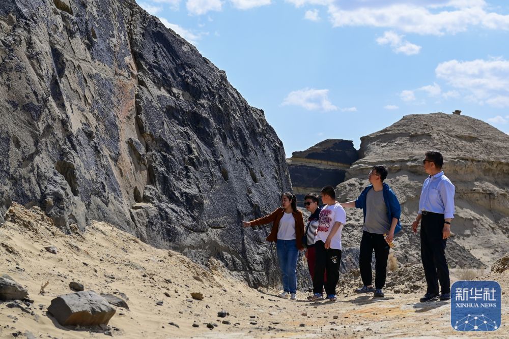 在新疆克拉玛依市乌尔禾区，游客在天然沥青矿参观游览（5月1日摄）。