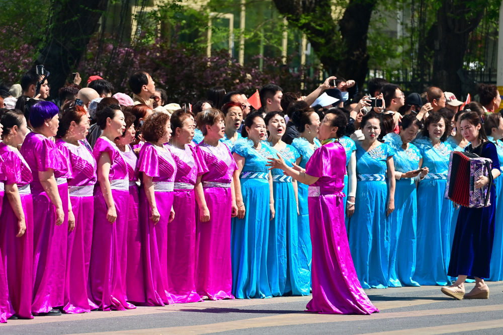 ↑这是4月30日在新疆乌鲁木齐市举行的巡游活动上拍摄的手风琴演奏及合唱表演。