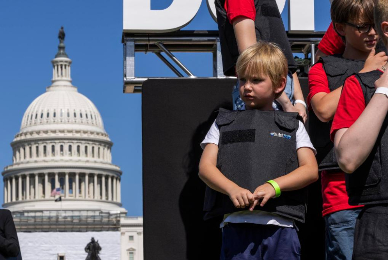 2022年6月6日，学生们身穿防弹衣在美国华盛顿的国会大厦前参加名为“不要回避”的抗议活动，呼吁立法机构正视美国枪击案频发的社会问题，要求加强枪支管控立法。新华社发（亚伦摄）