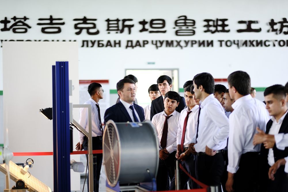 ↑6月14日，学生们在塔吉克斯坦首都杜尚别的鲁班工坊内听塔方老师讲解。