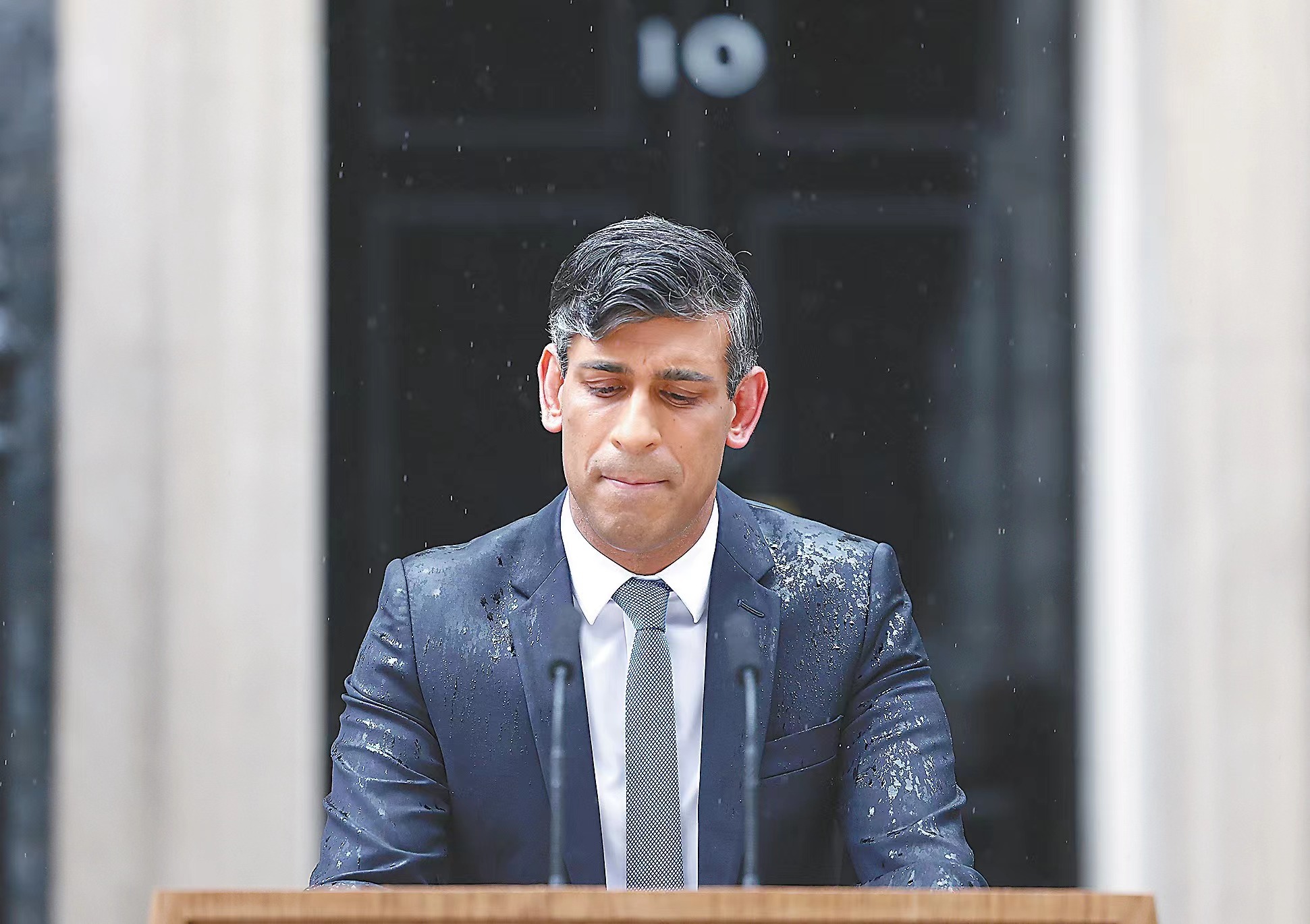 22日唐宁街10号前,英国首相苏纳克在雨中宣布,英国将于7月4日举行大选。(视觉中国)