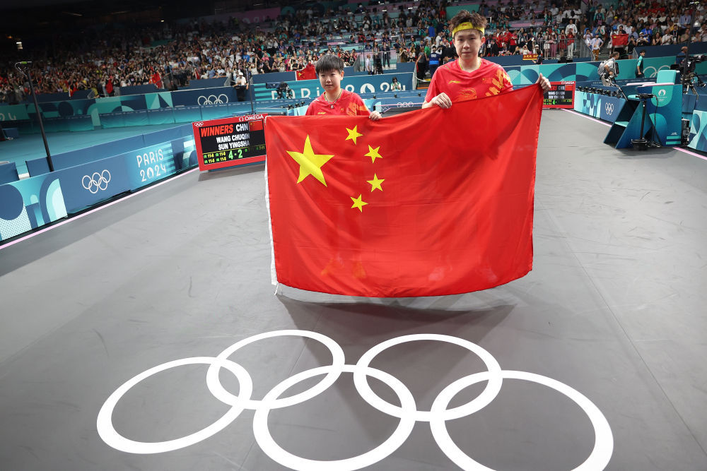 ↑7月30日,王楚钦(右)和孙颖莎在夺冠后庆祝。新华社记者刘续摄