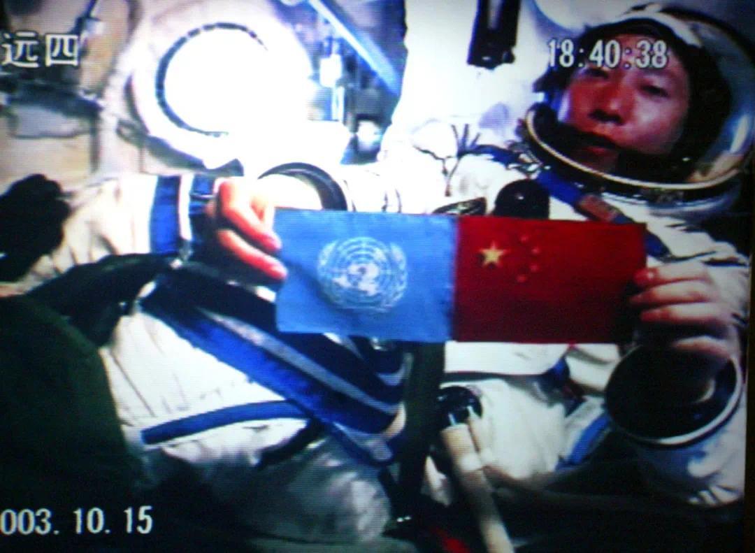 2003年10月15日，中国第一位航天员杨利伟从太空向世界各国人民问好，并在舱内并列展示了五星红旗和联合国旗（摄于北京航天指挥控制中心大屏幕）。新华社记者 赵建伟 摄