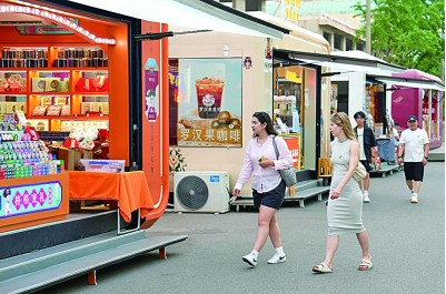 两名外国游客在北京市王府井大街参观游览。新华社记者 鞠焕宗摄