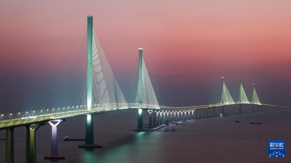 暮色中的黄茅海跨海通道高栏港大桥（左侧双主塔）和黄茅海大桥（右侧三主塔）（2024年12月7日摄，无人机照片）。