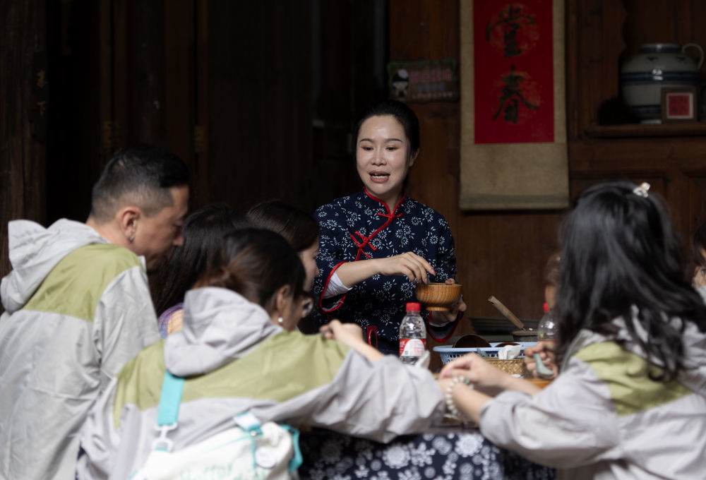 在尚书巷历史文化街区的大龙擂茶传承所，非遗传承人李华给来自厦门的游客制作擂茶（4月19日摄）。