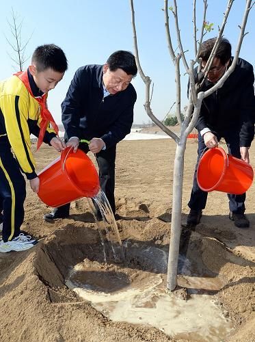 （2014年4月，习近平总书记在团城湖调节池参加义务植树活动）