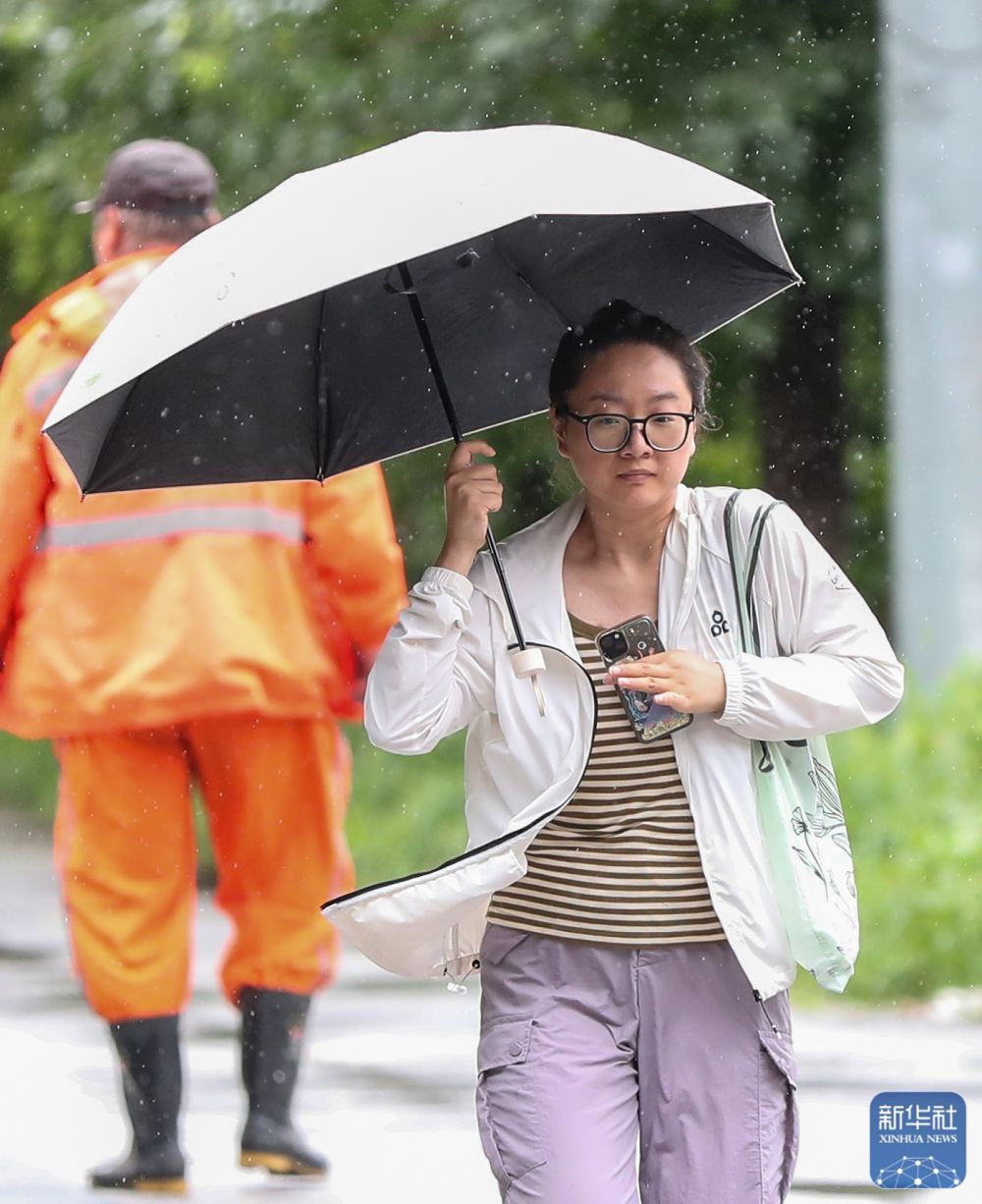 7月28日，在辽宁省沈阳市大东区，市民在雨中出行。新华社记者龙雷摄