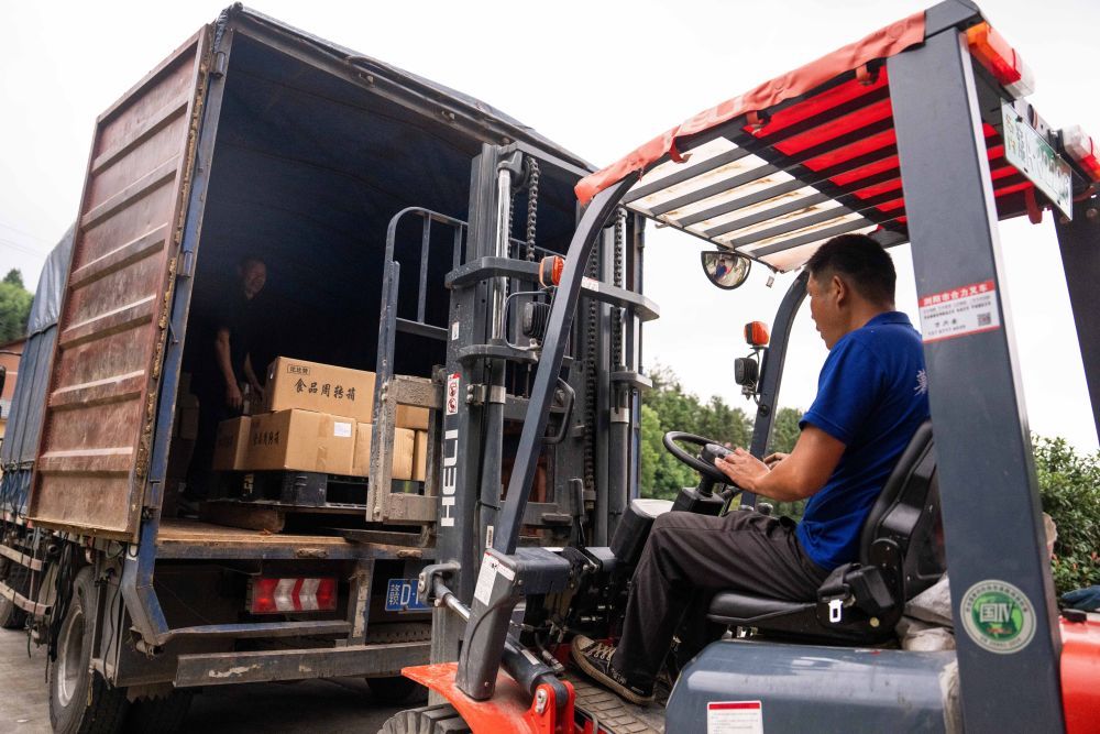 6月5日，在浏阳市关口街道道源湖村一家粽子生产车间，工人在运输打包好的粽子。