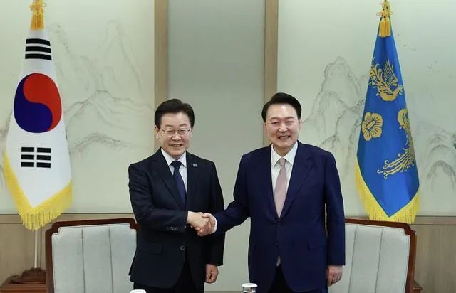 4月29日，尹锡悦（左）与李在明（右）会面时握手