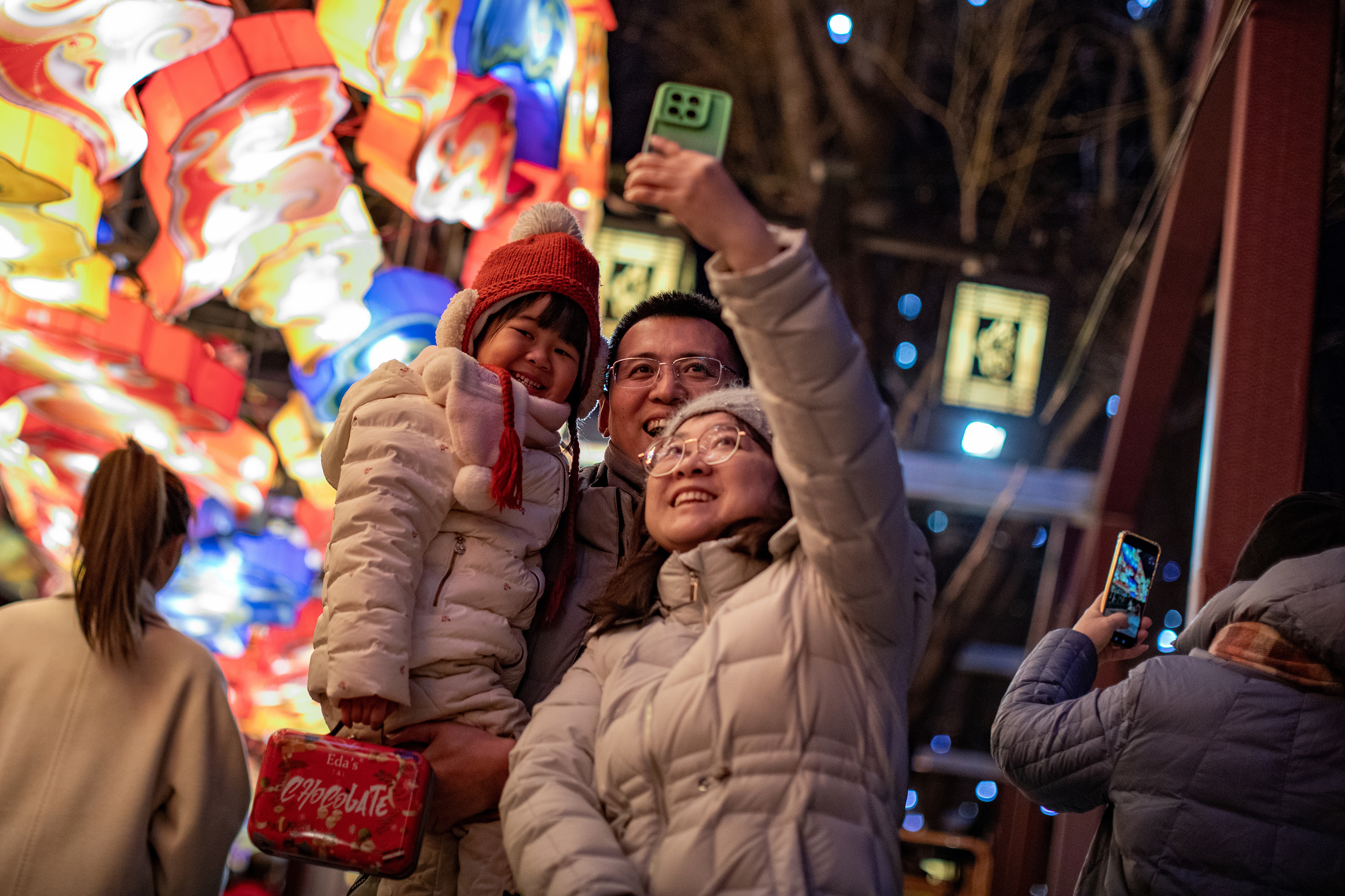 △ 2024年2月8日晚，北京，什刹海畔荷花市场上空，200余米的“蛟龙出海”巨型龙灯点亮，吸引市民打卡拍照。